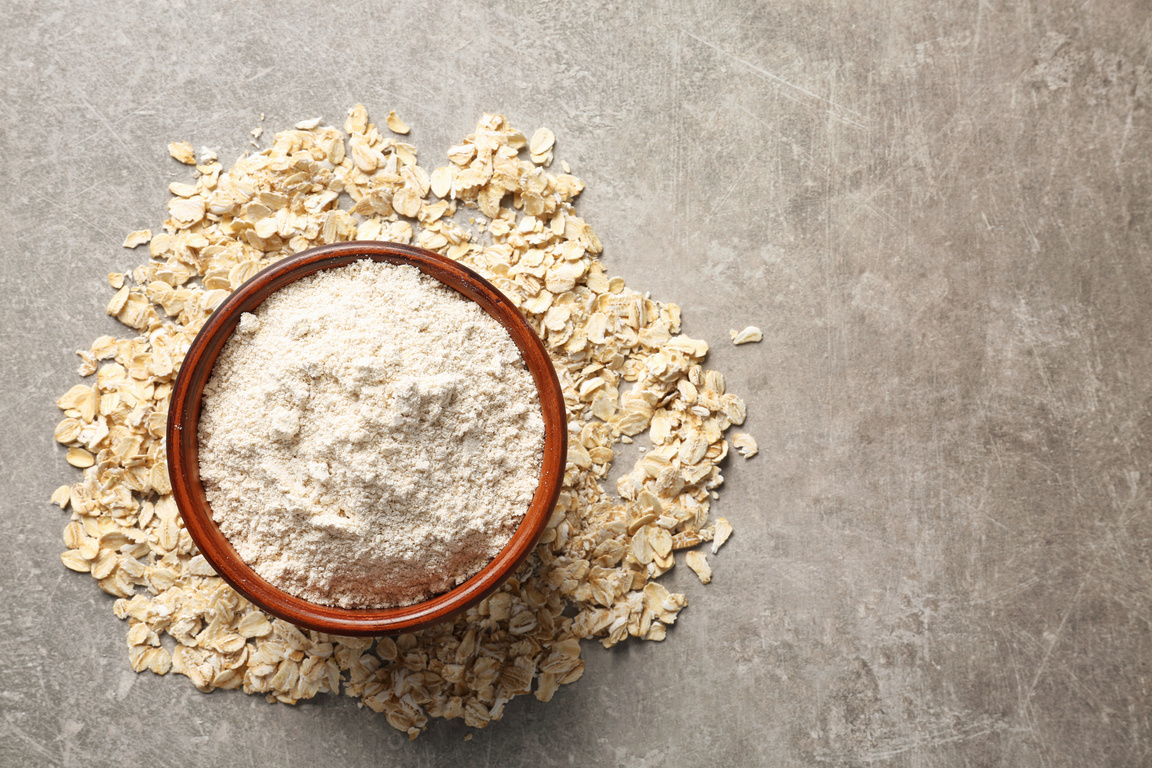 Bowl with Oat Flour on Gray Background